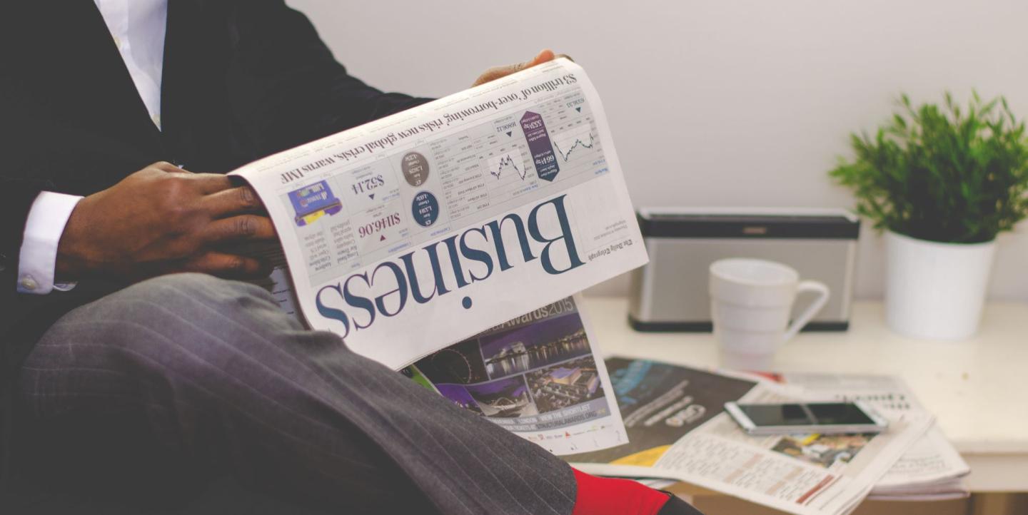 African man holding a newspaper