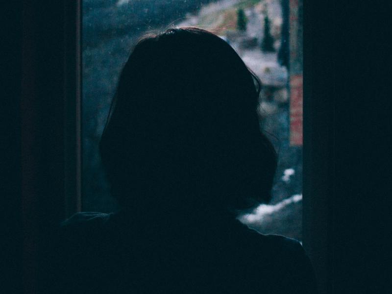 Woman looking out a rainy window