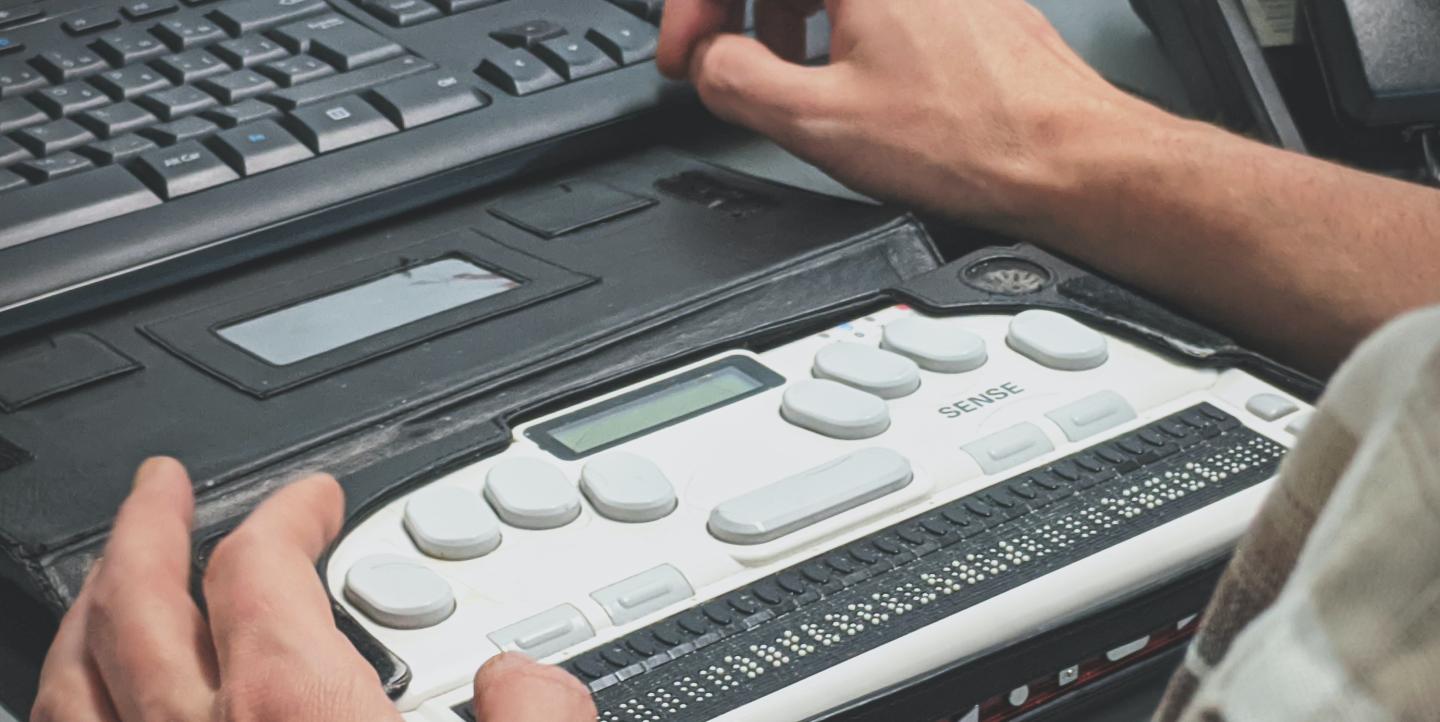 Слепой человек использует скринридер с шрифтом Брайля 