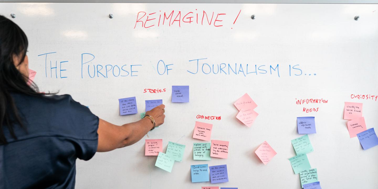 Mujer coloca notas adhesivas con palabras escritas en ellas en una pizarra blanca