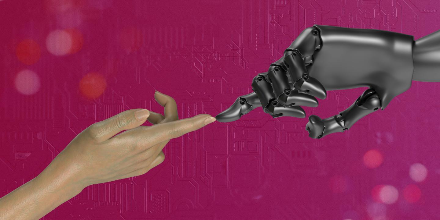 A human hand touching a robot hand.