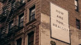 Sign reading, "How are you, really?" on a building