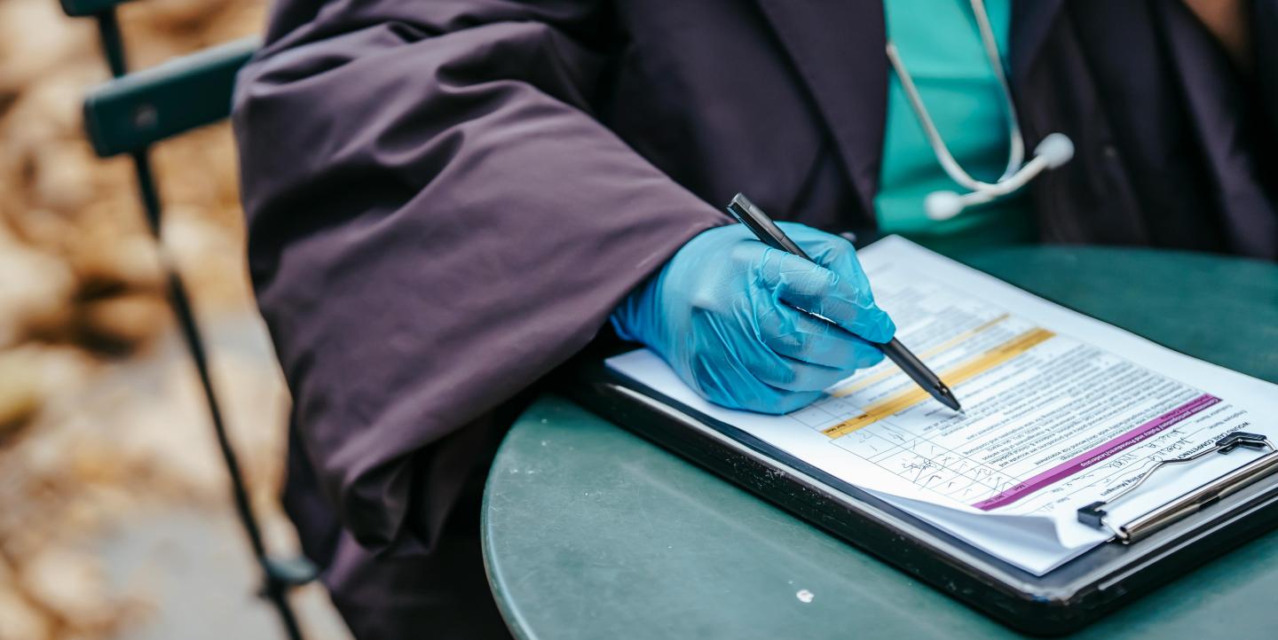 A doctor filling out a health form