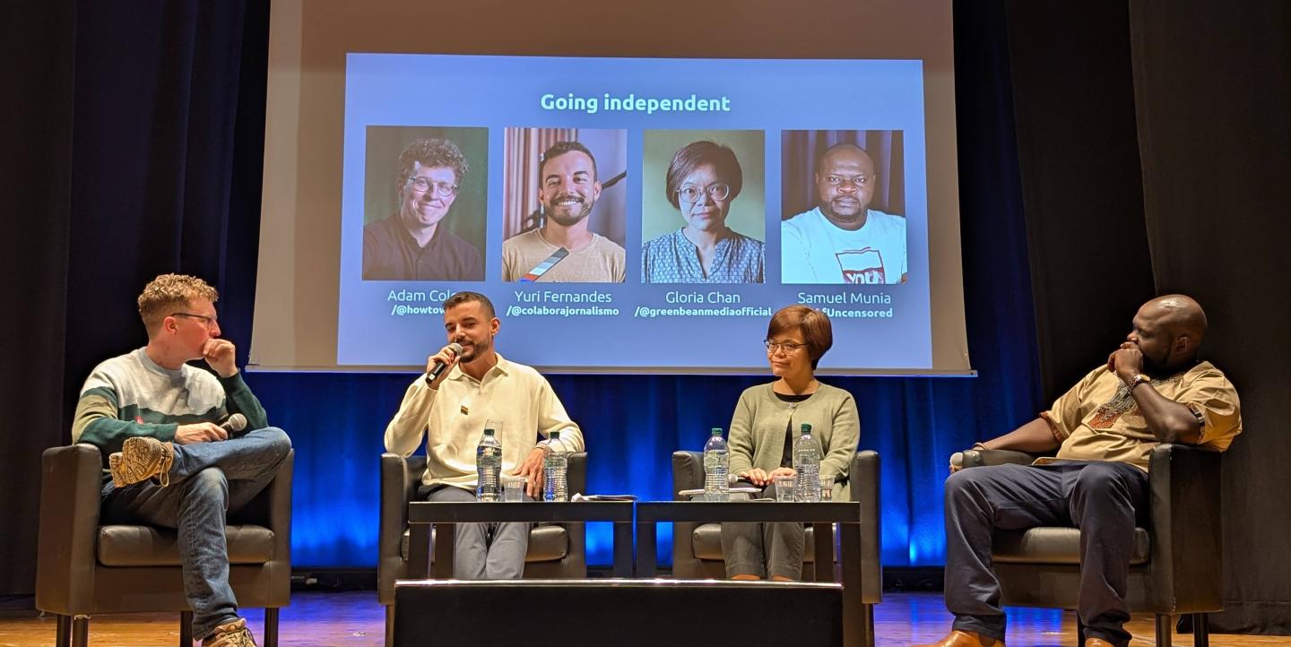 Adam Cole, Yuri Fernandes, Gloria Chan, and Samuel Munia sitting in front of a screen with their names on in it. 