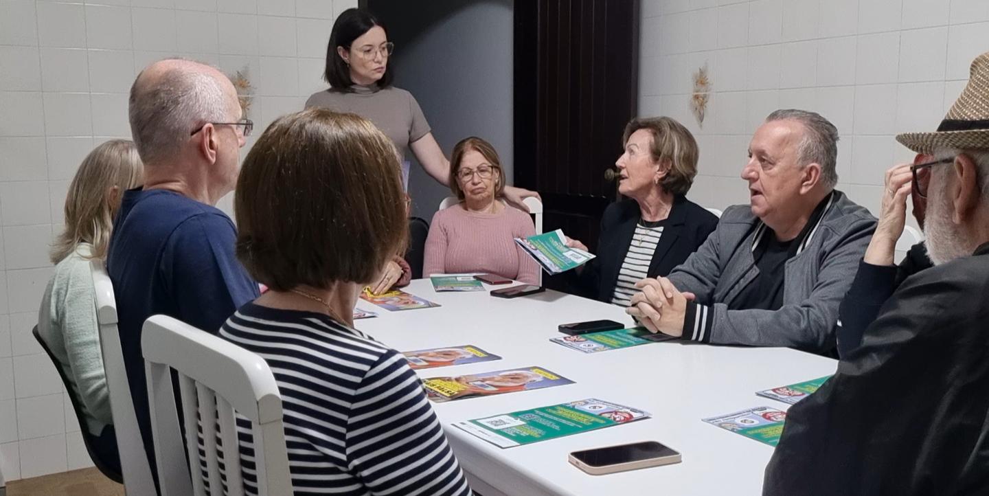 Talita standing at a table full of workshop attendees.